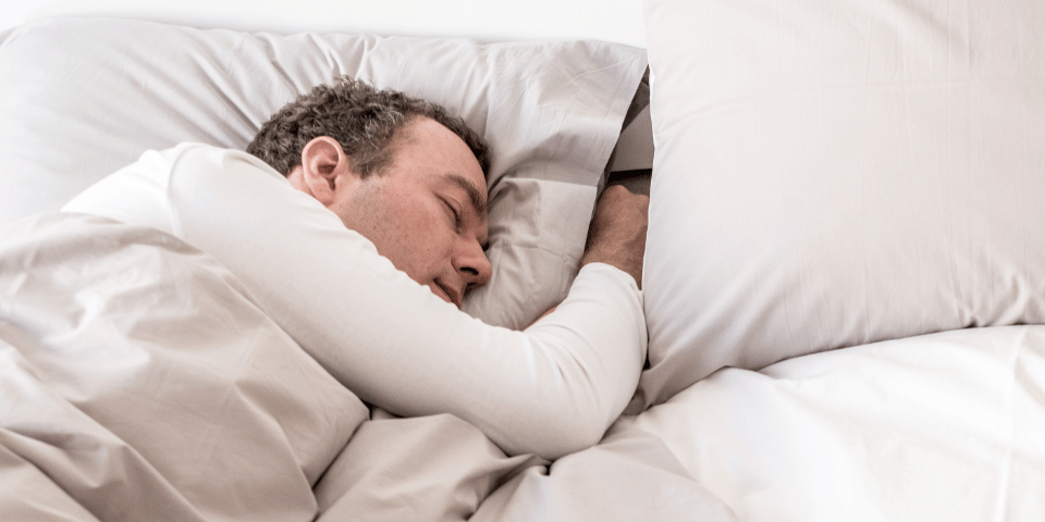 Mann schläft im Bett