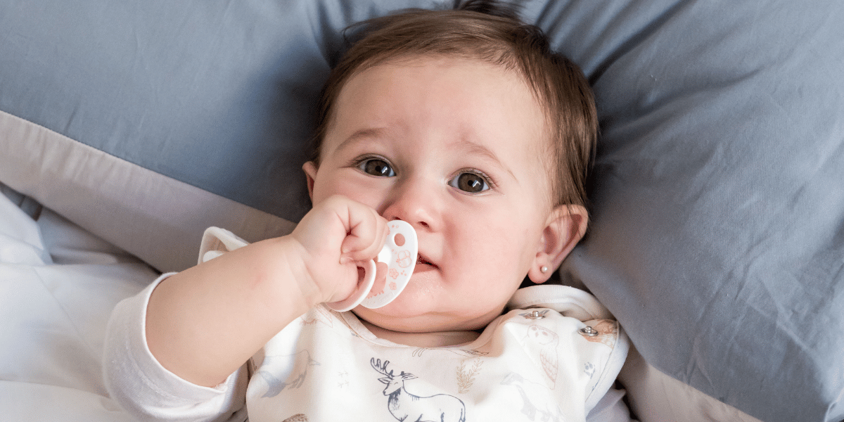 Baby im Schlafsack im Bett