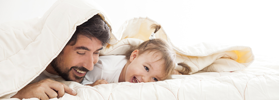 Man and child underneath a Zizzz duvet