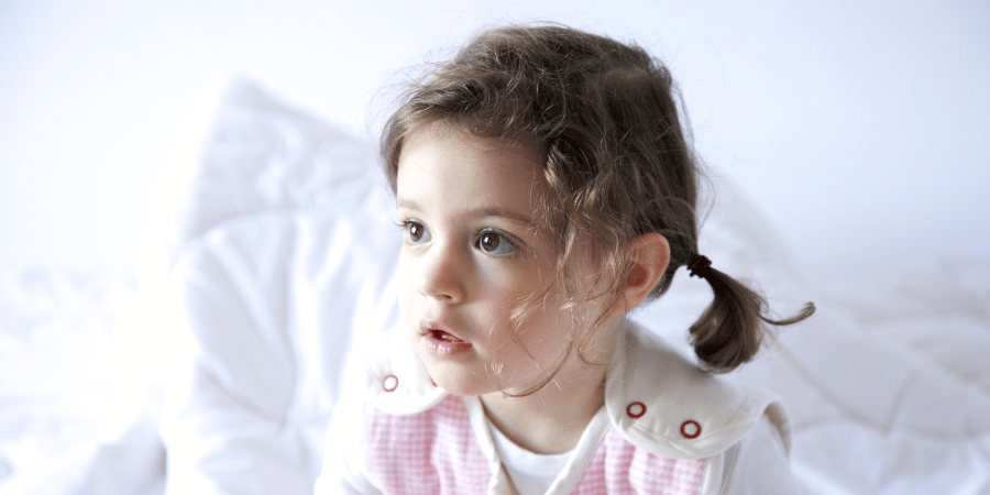 Little girl in bed looking dreamy