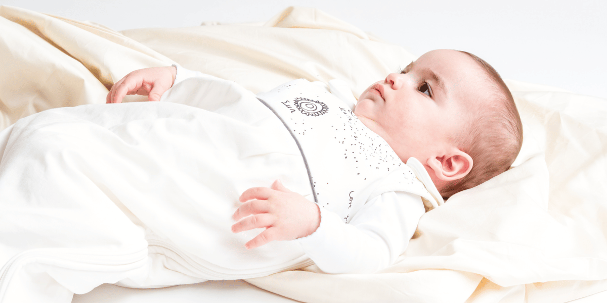 Bébé sur une pile de gigoteuses