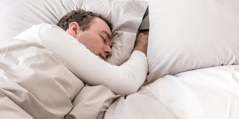 Homme qui dort dans son linge de lit percale