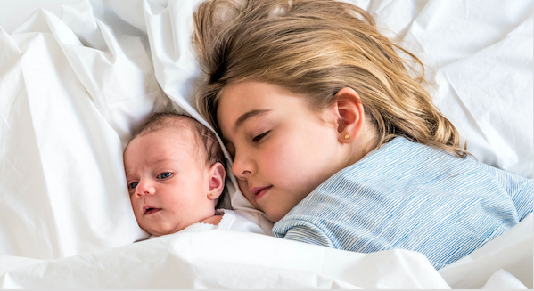 Bébé endormi avec sa grande soeur 