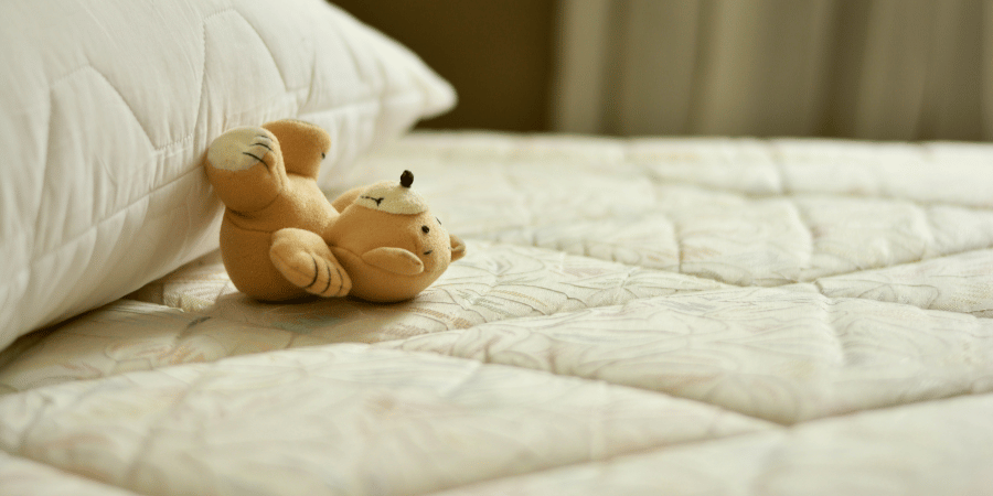 matelas avec une petite peluche posée dessus