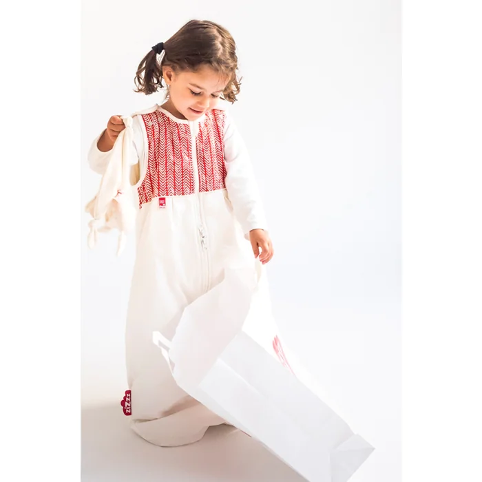 Petite fille avec un sac et une gigoteuse herringbone